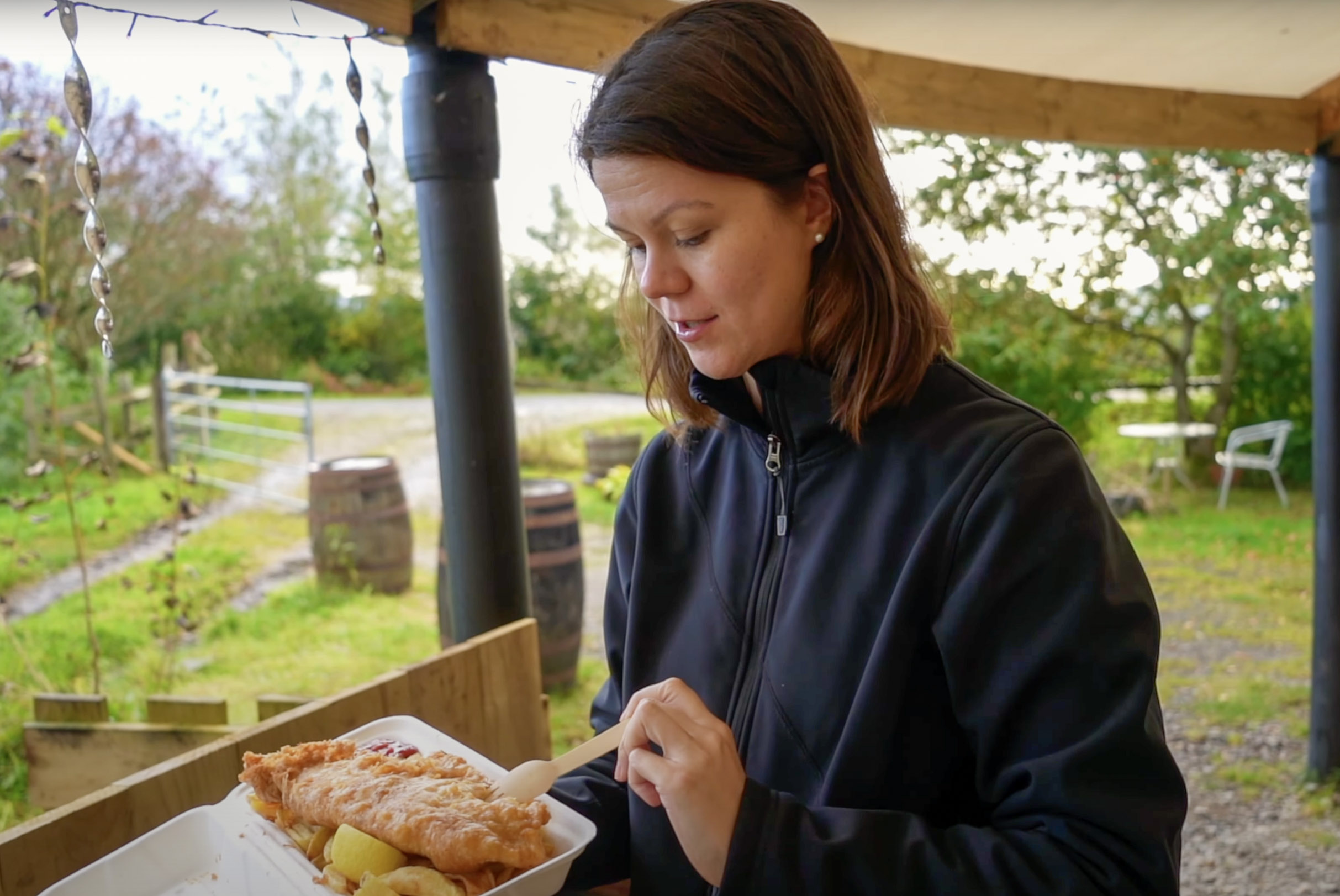 a girl eating fish and chips in Scotland outside