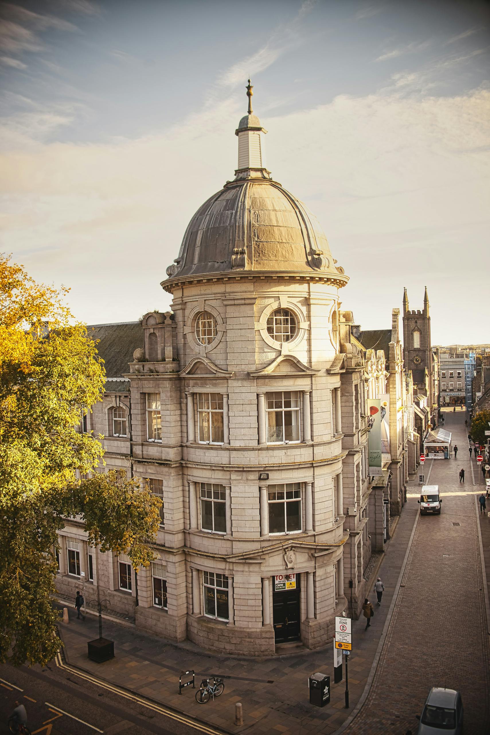 A scenic view of historic architecture on a vibrant street in Aberdeen, Scotland.
