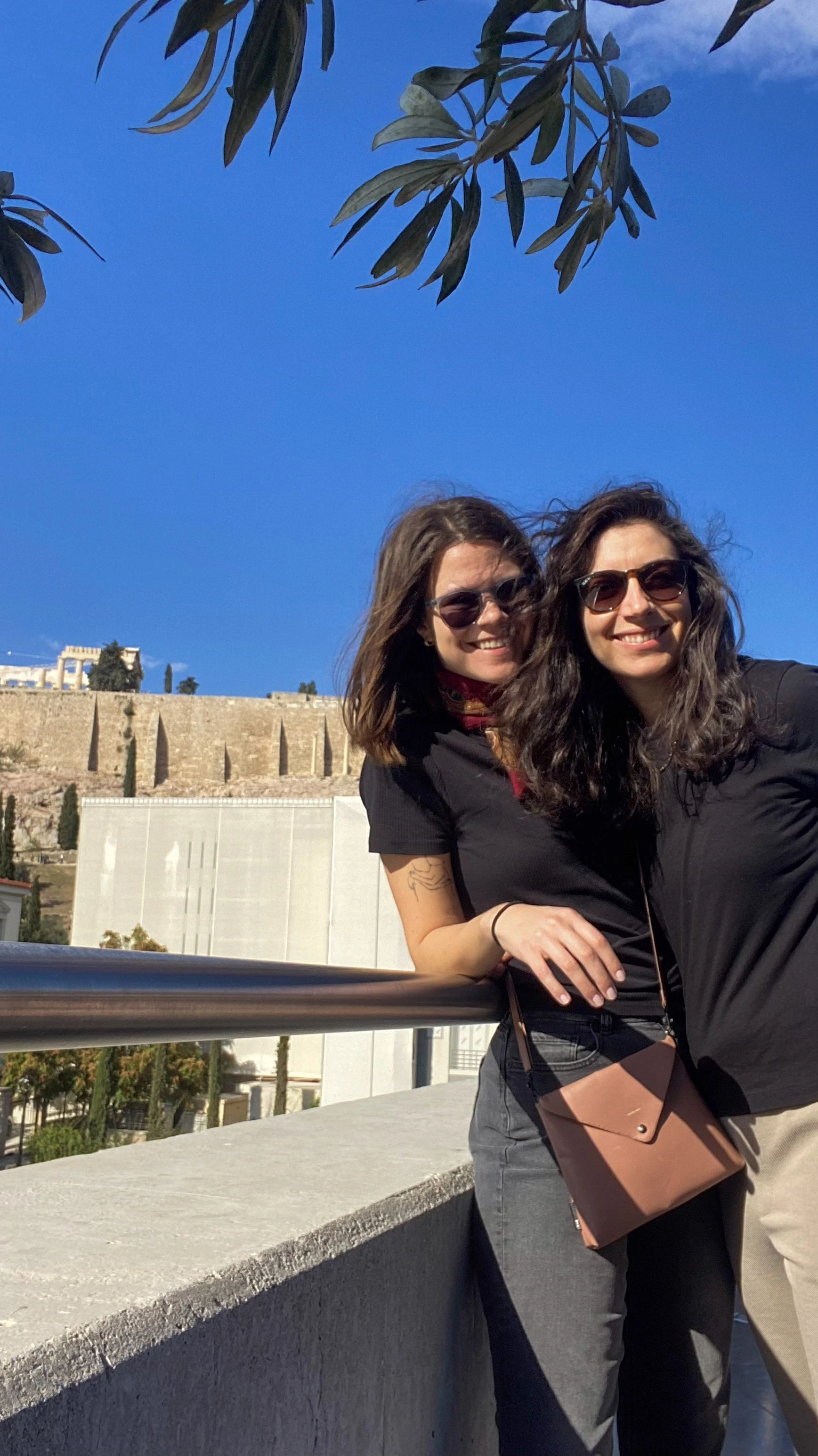 maria and olivia travel bloggers from athens at the acropolis museum standing at the cafe for an image