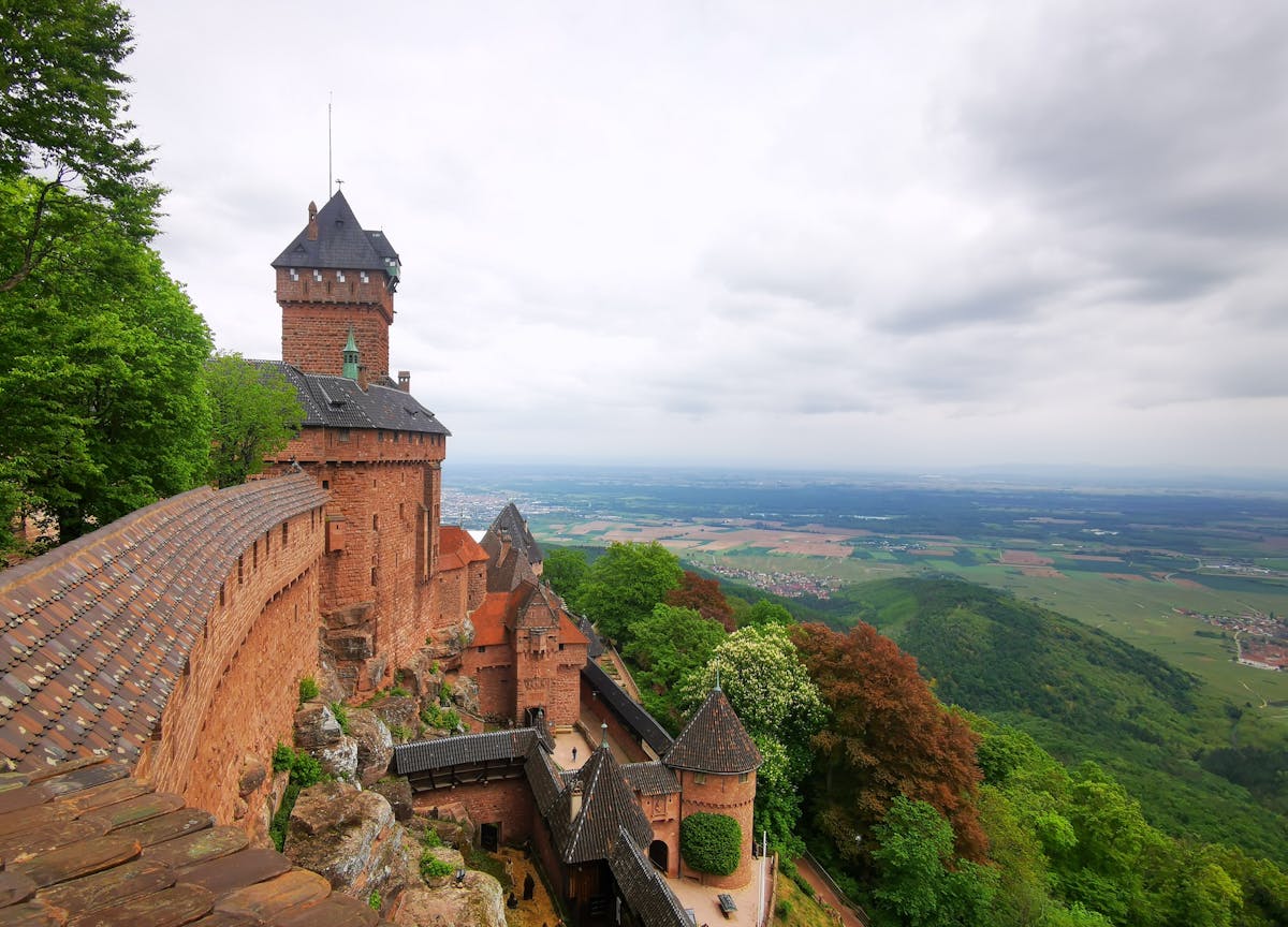 A breathtaking landscape view from Haut-Koenigsbourg Castle in Orschwiller, showcasing lush greenery and vast fields.