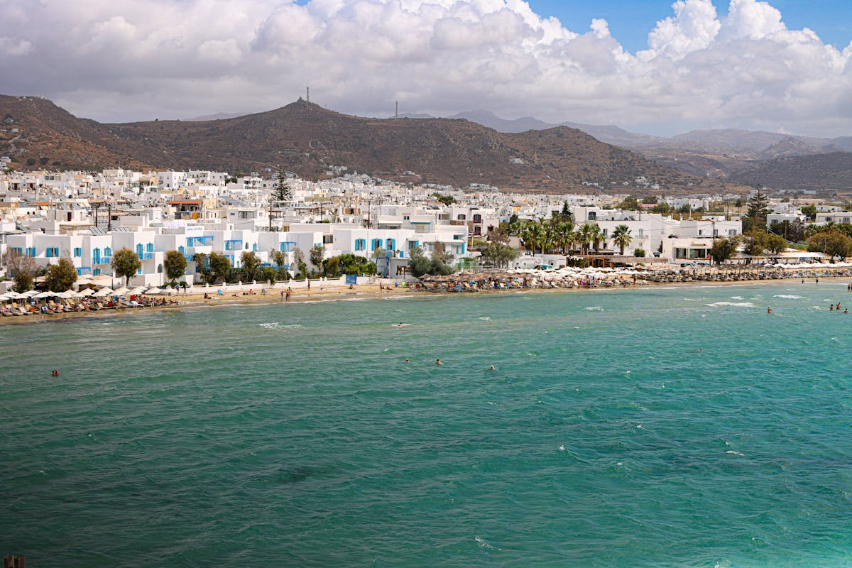Stunning aerial view of Naxos beach with turquoise waters and white buildings.