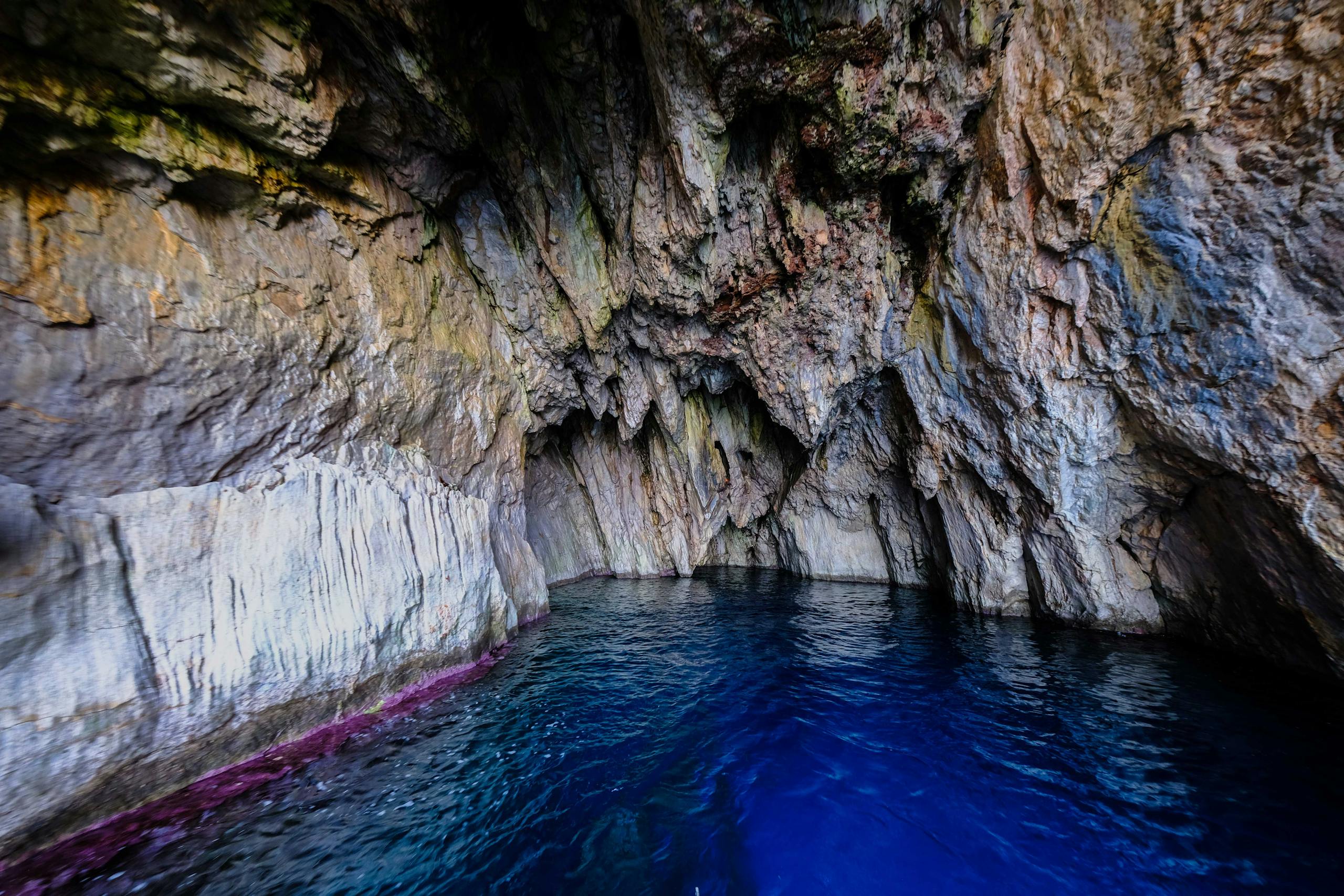 Experience the stunning beauty of a natural sea cave with vibrant blue waters and rocky textures.