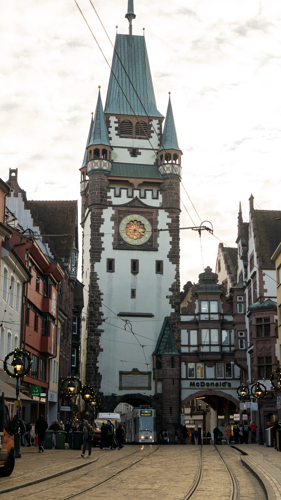 martinstor clock tower on a busy street in freiburg, germany's black forest region