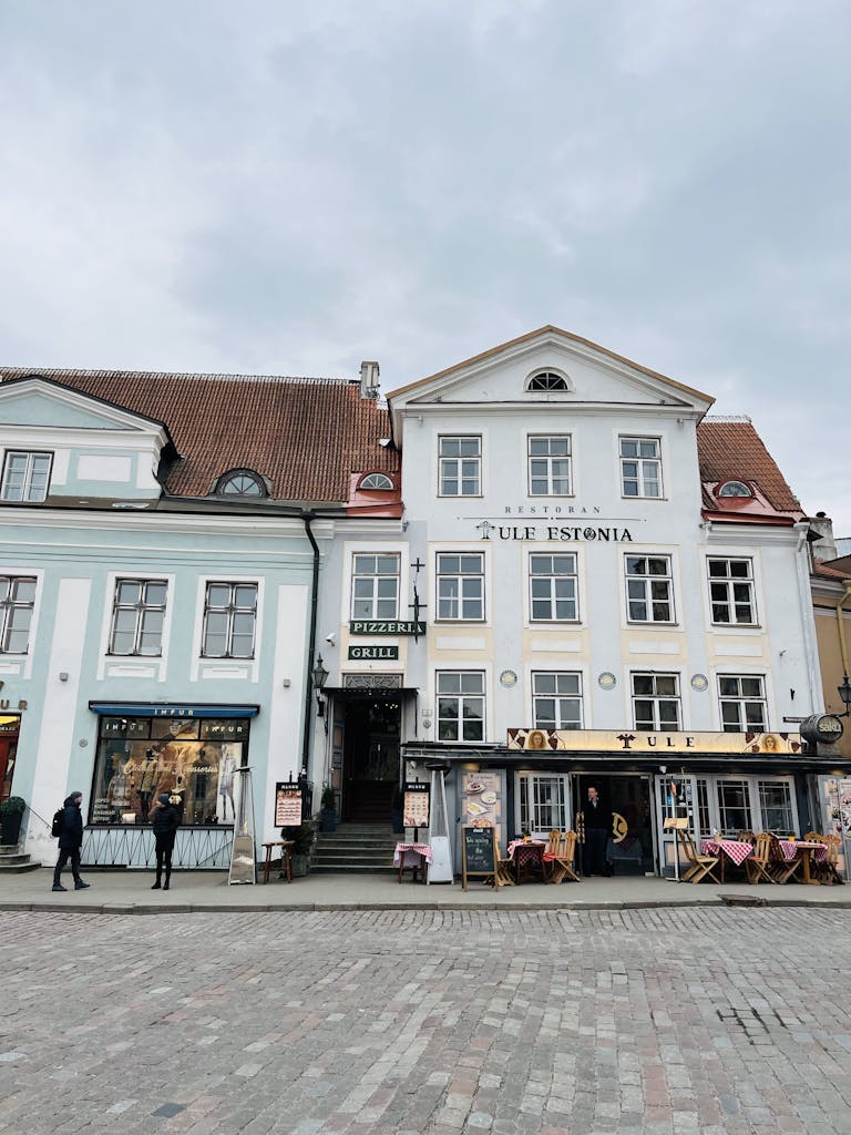 Scenic view of historic Tallinn street with colorful buildings and local eateries.