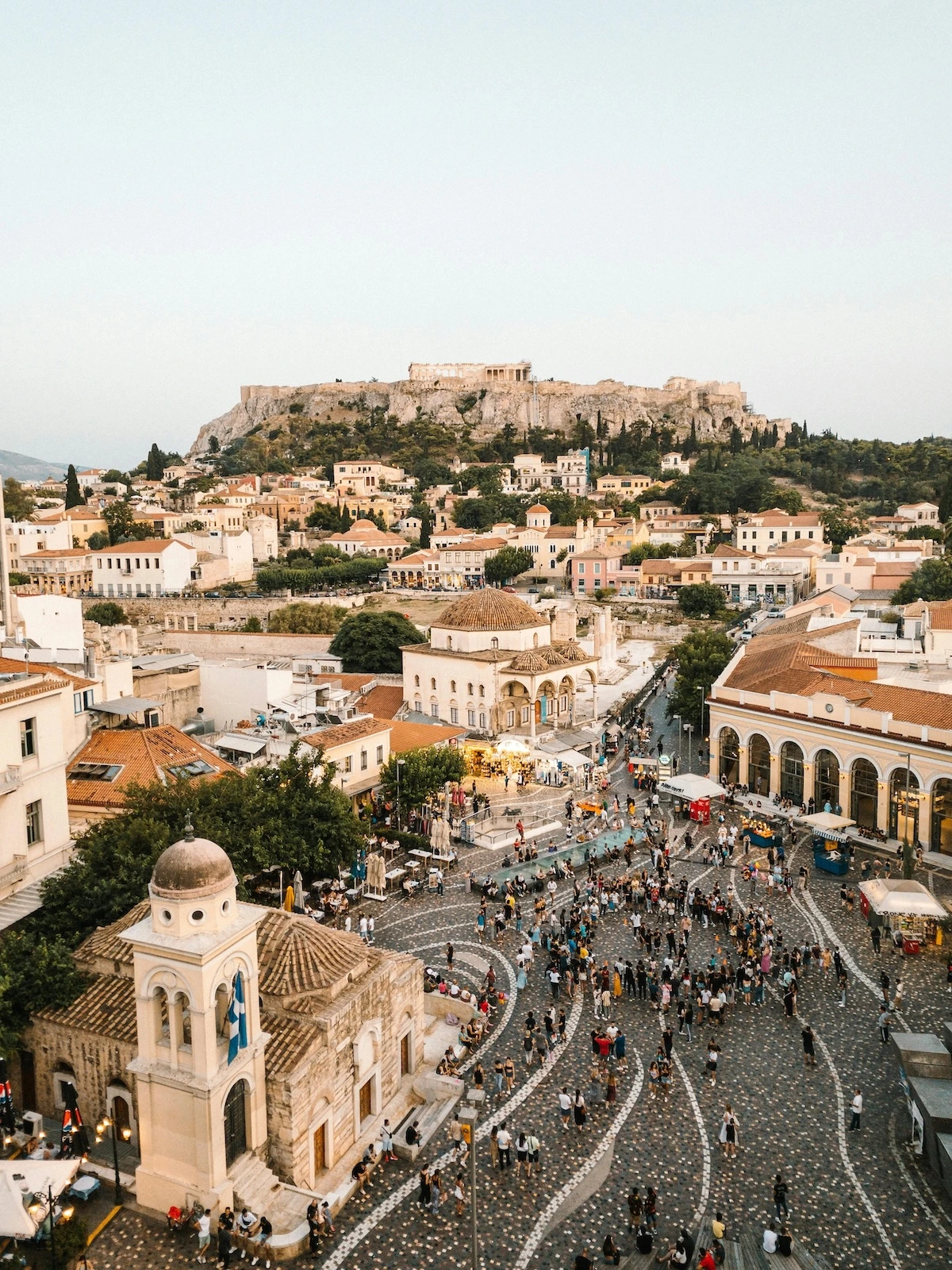athens skyline from above with a square filled with people and the acropolis above